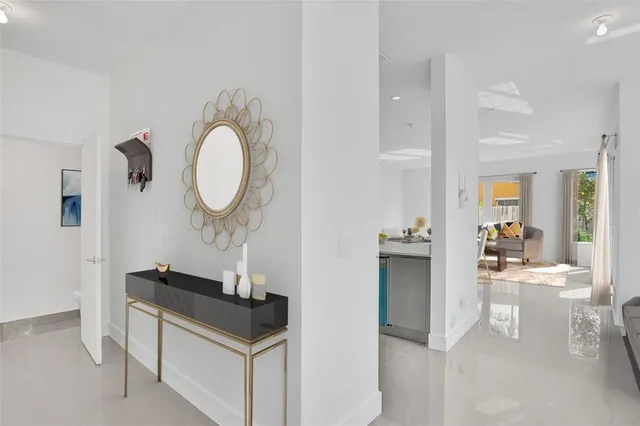 a living room with kitchen island a sink and a stove with wooden floor