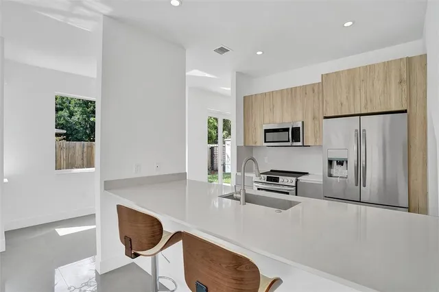 a kitchen with stainless steel appliances a refrigerator and a stove top oven