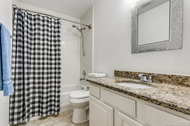 a bathroom with a granite countertop sink toilet and shower