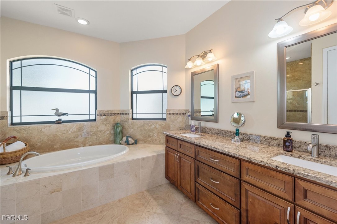 2011 Northwest 9th Place Cape Coral, FL 33993 - Photo 12 of 22 a spacious bathroom with a granite countertop tub sink and mirror