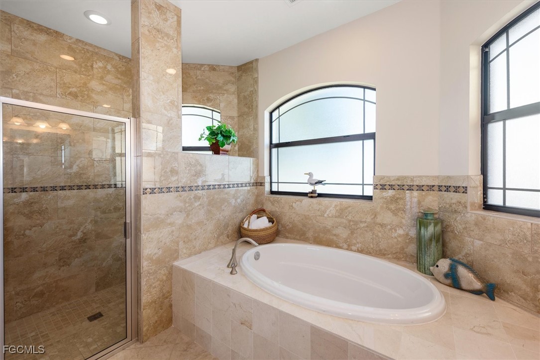 2011 Northwest 9th Place Cape Coral, FL 33993 - Photo 13 of 22 a bathroom with a sink a bathtub and a shower