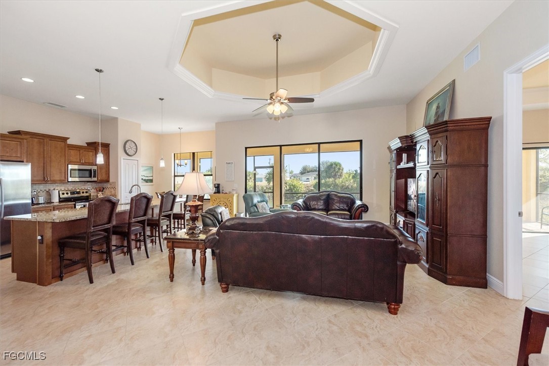 2011 Northwest 9th Place Cape Coral, FL 33993 - Photo 2 of 22 a living room with furniture a chandelier and a large window