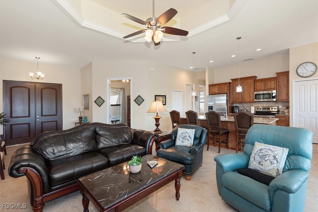 2011 Northwest 9th Place Cape Coral, FL 33993 - Photo 5 of 22 a living room with furniture kitchen view and a chandelier