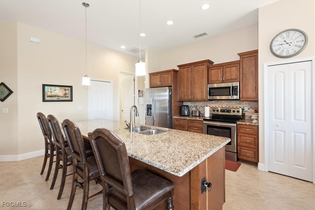 2011 Northwest 9th Place Cape Coral, FL 33993 - Photo 6 of 22 a kitchen with stainless steel appliances kitchen island granite countertop a kitchen island hardwood floor and a sink