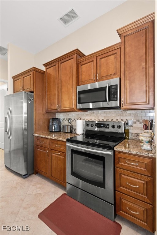 2011 Northwest 9th Place Cape Coral, FL 33993 - Photo 9 of 22 a kitchen with stainless steel appliances granite countertop a stove a sink and a refrigerator