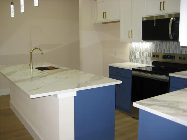 a kitchen with a sink cabinets and a wooden floor