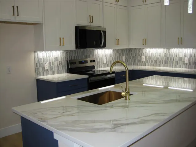 a kitchen with a sink a stove and cabinets