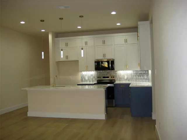 a kitchen with stainless steel appliances granite countertop a sink and a stove