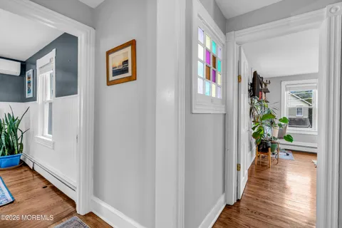 a view of a hallway with wooden floor and windows