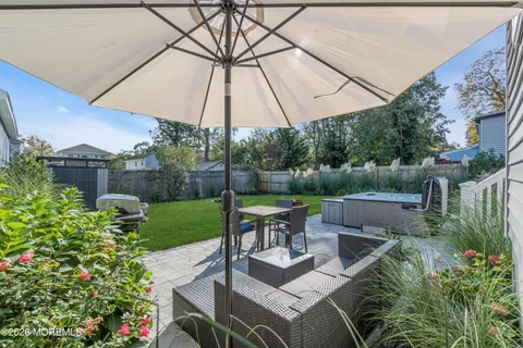 a view of a patio with furniture and a garden