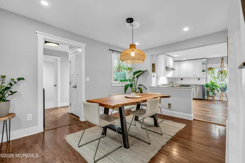 a view of a dining room and livingroom with furniture wooden floor a chandelier