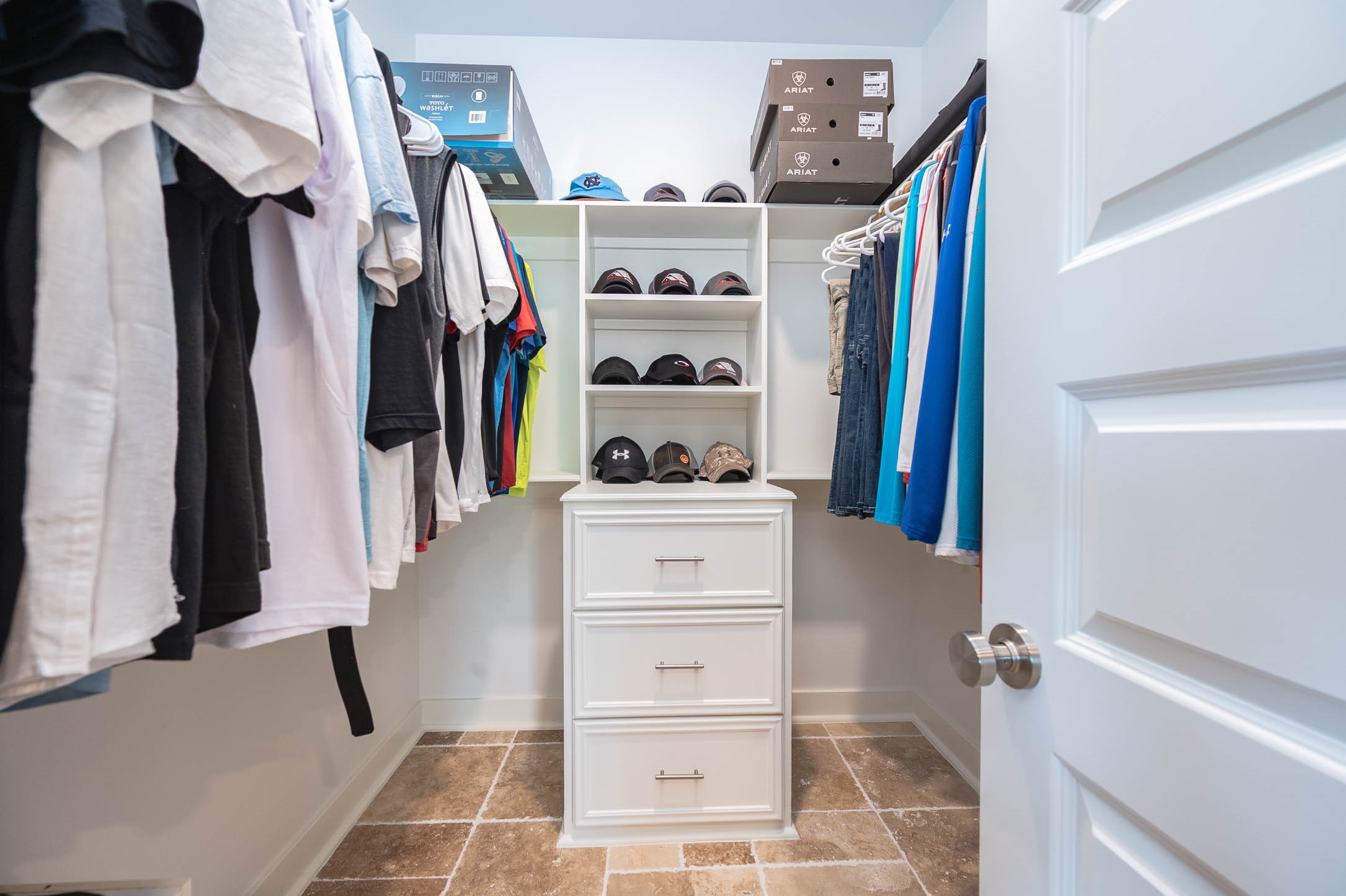 8032 Short Road Needville, TX 77461 - Photo 21 of 50 The spacious walk-in primary closet offers ample hanging space, built-in shelving, and additional storage drawers to keep everything organized. Bright finishes and a functional layout make this space both practical and inviting.