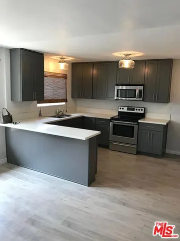 a kitchen with stainless steel appliances a sink and a microwave