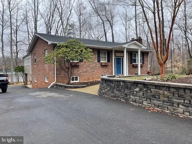 a front view of a house with a tree