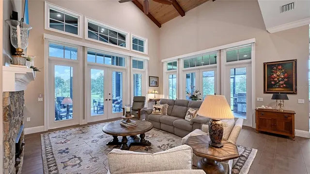 a living room with furniture fireplace and floor to ceiling windows