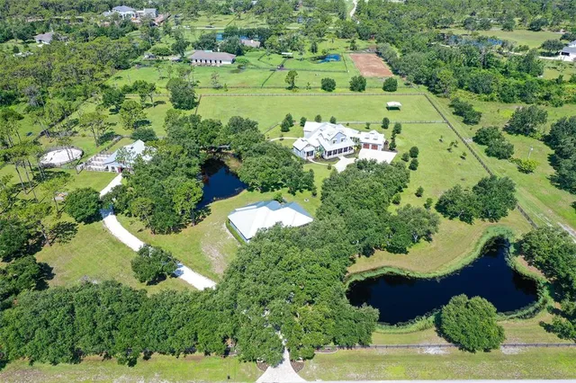 an aerial view of a house with a yard basket ball court and outdoor seating