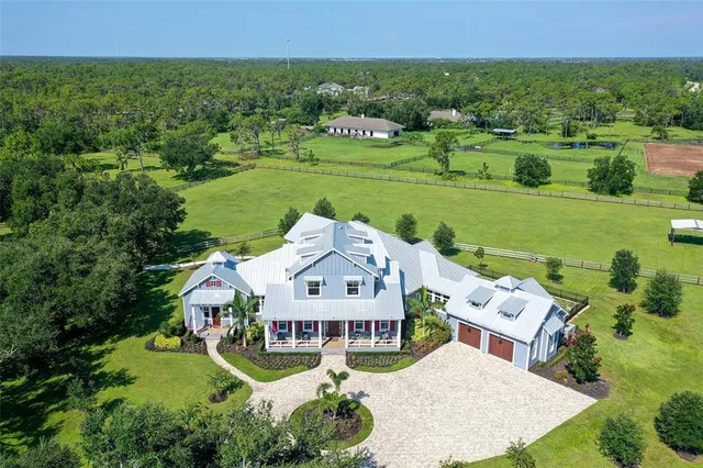 a view of a porch with couches potted plants and wooden fence