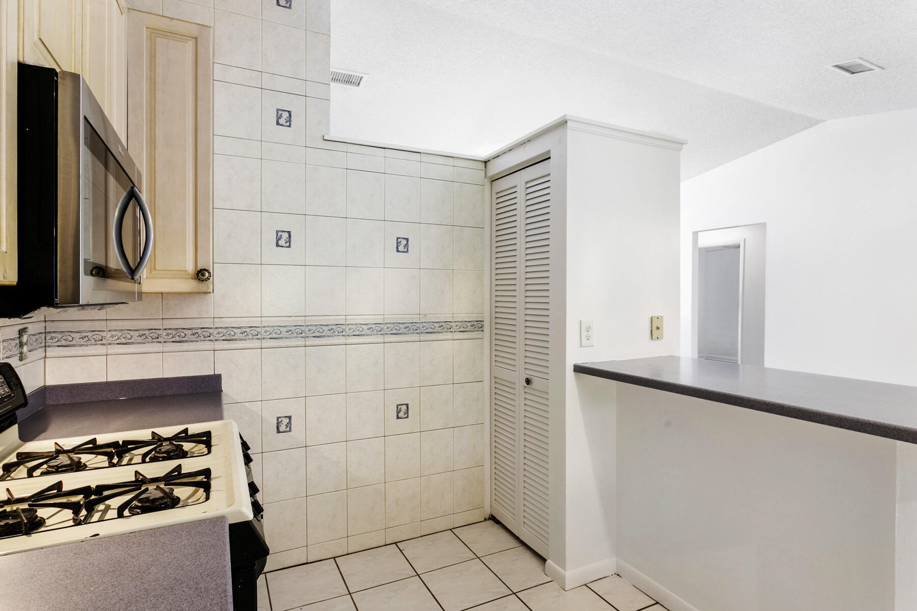 6075 Wolfe Street Jupiter, FL 33458 - Photo 11 of 27 a kitchen with granite countertop a stove and a refrigerator