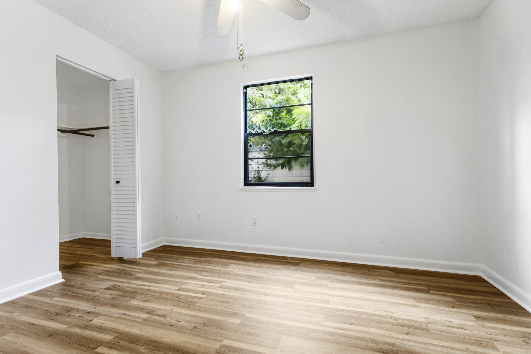 6075 Wolfe Street Jupiter, FL 33458 - Photo 20 of 27 an empty room with wooden floor and windows