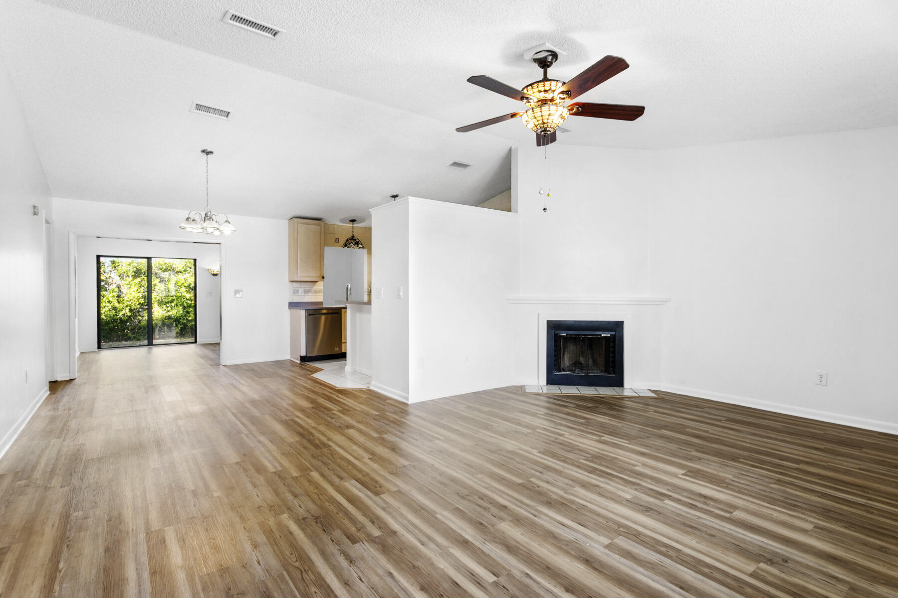 6075 Wolfe Street Jupiter, FL 33458 - Photo 2 of 27 an empty room with chandelier fan and wooden floor