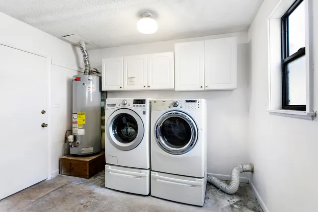 a utility room with dryer washer and a view of living room