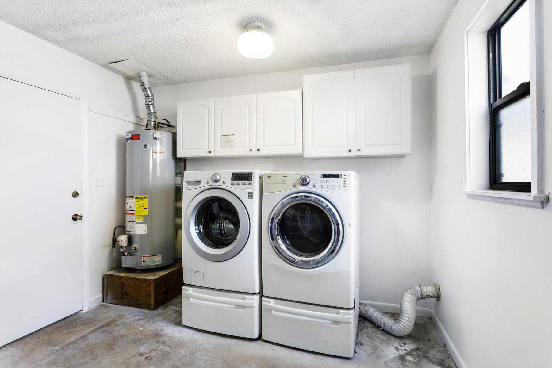 6075 Wolfe Street Jupiter, FL 33458 - Photo 23 of 27 a utility room with dryer washer and a view of living room