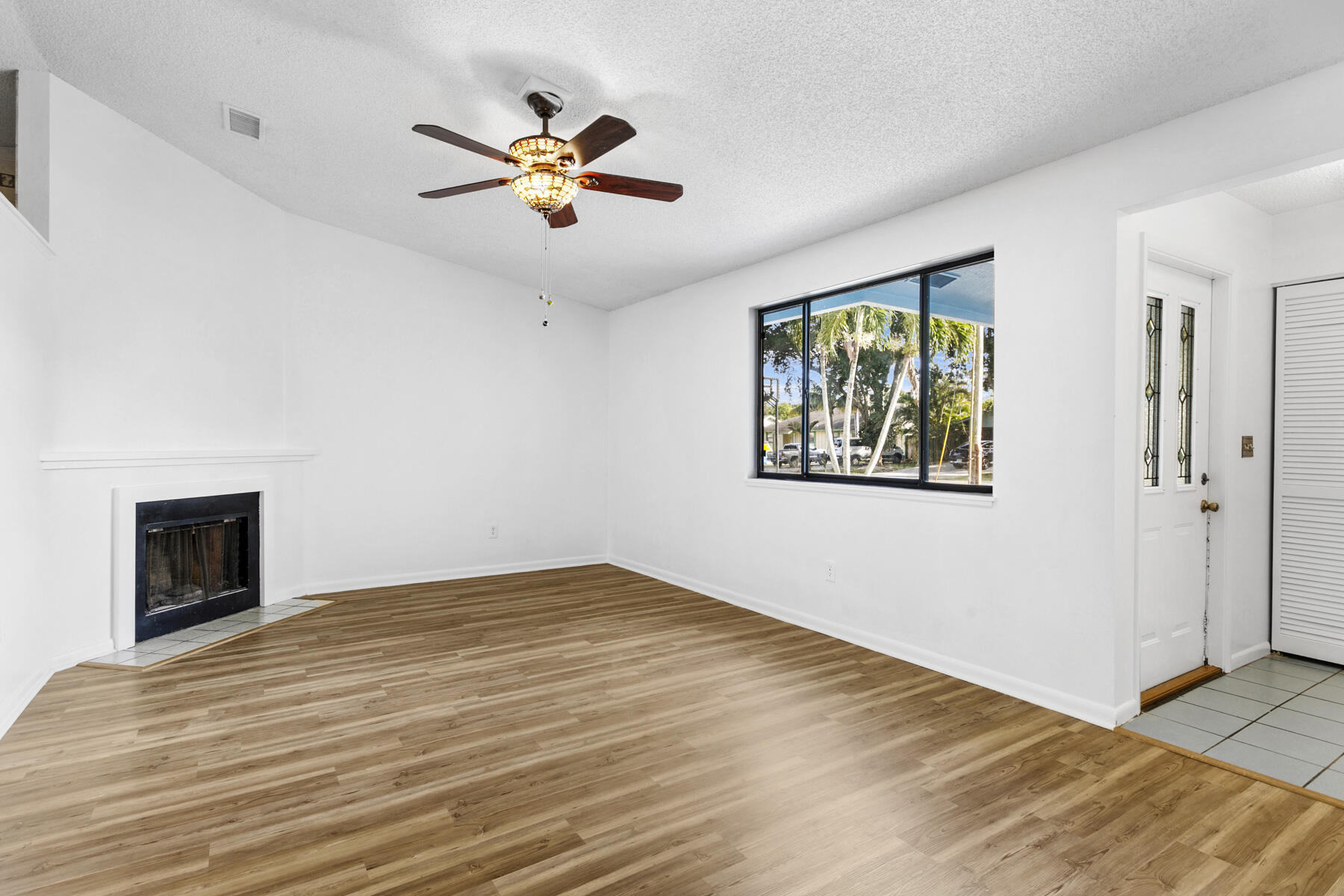 6075 Wolfe Street Jupiter, FL 33458 - Photo 3 of 27 a view of an empty room with window and wooden floor