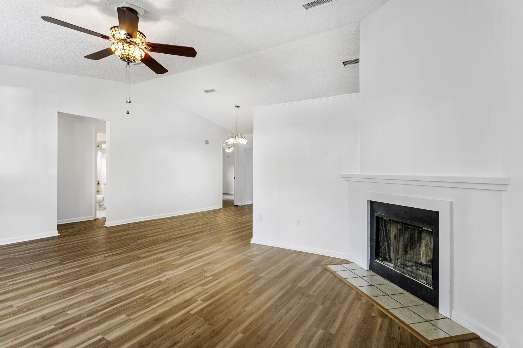 6075 Wolfe Street Jupiter, FL 33458 - Photo 4 of 27 a view of a livingroom with a fireplace a chandelier fan and wooden floor