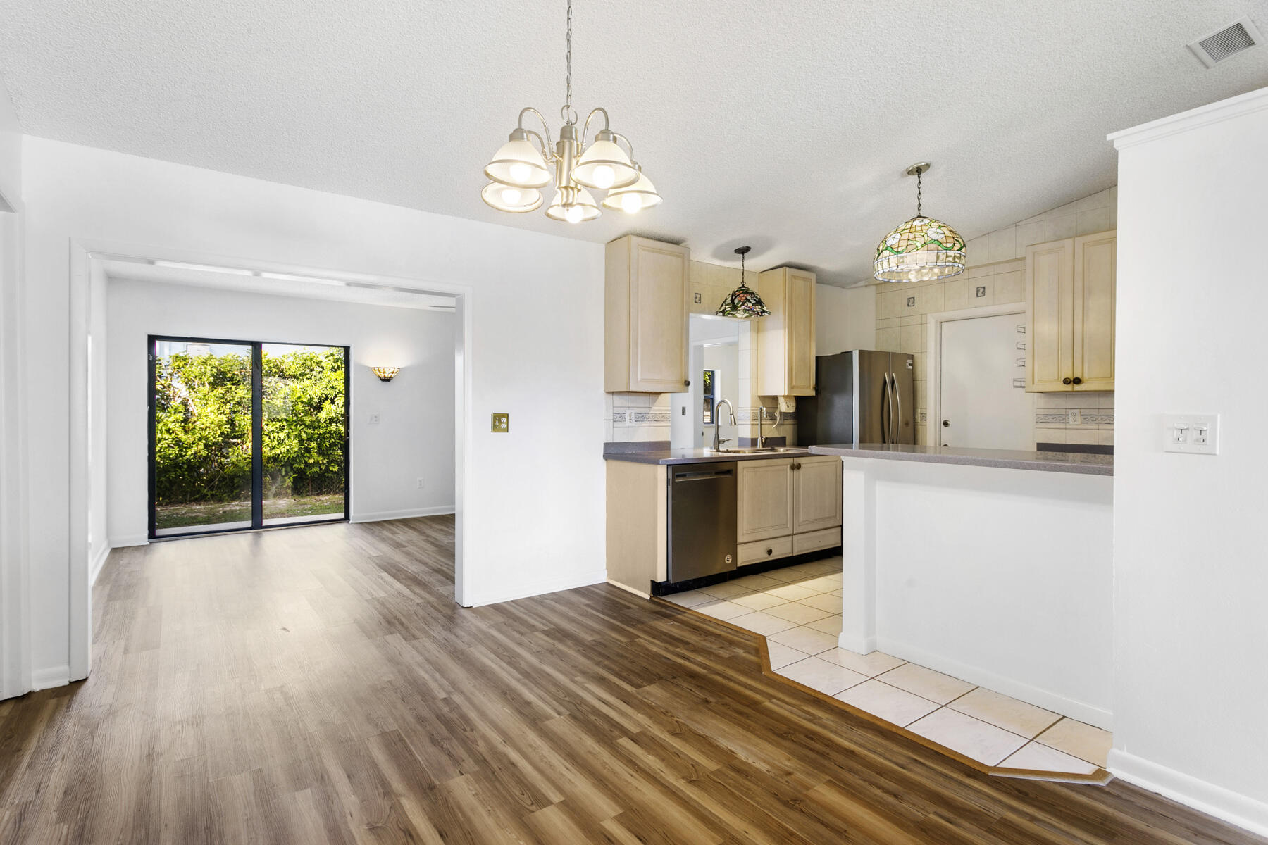 6075 Wolfe Street Jupiter, FL 33458 - Photo 6 of 27 a large kitchen with granite countertop a stove a sink dishwasher and a refrigerator with wooden floor