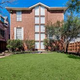 a front view of a house with a yard and trees
