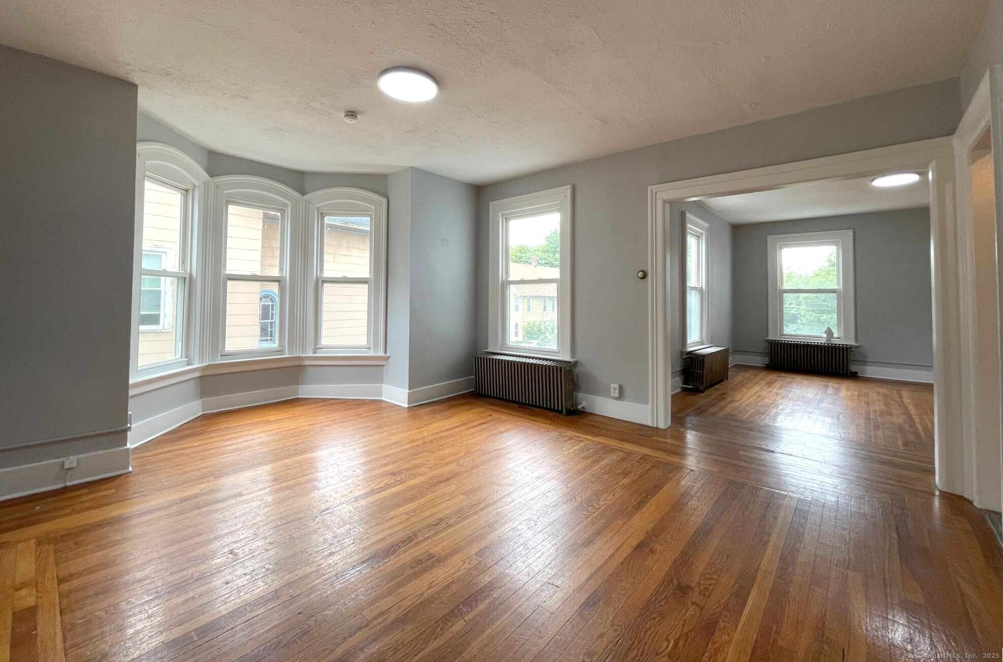 303 Lexington Avenue, Unit 2 New Haven, CT 06513 - Photo 3 of 11 an empty room with wooden floor and windows