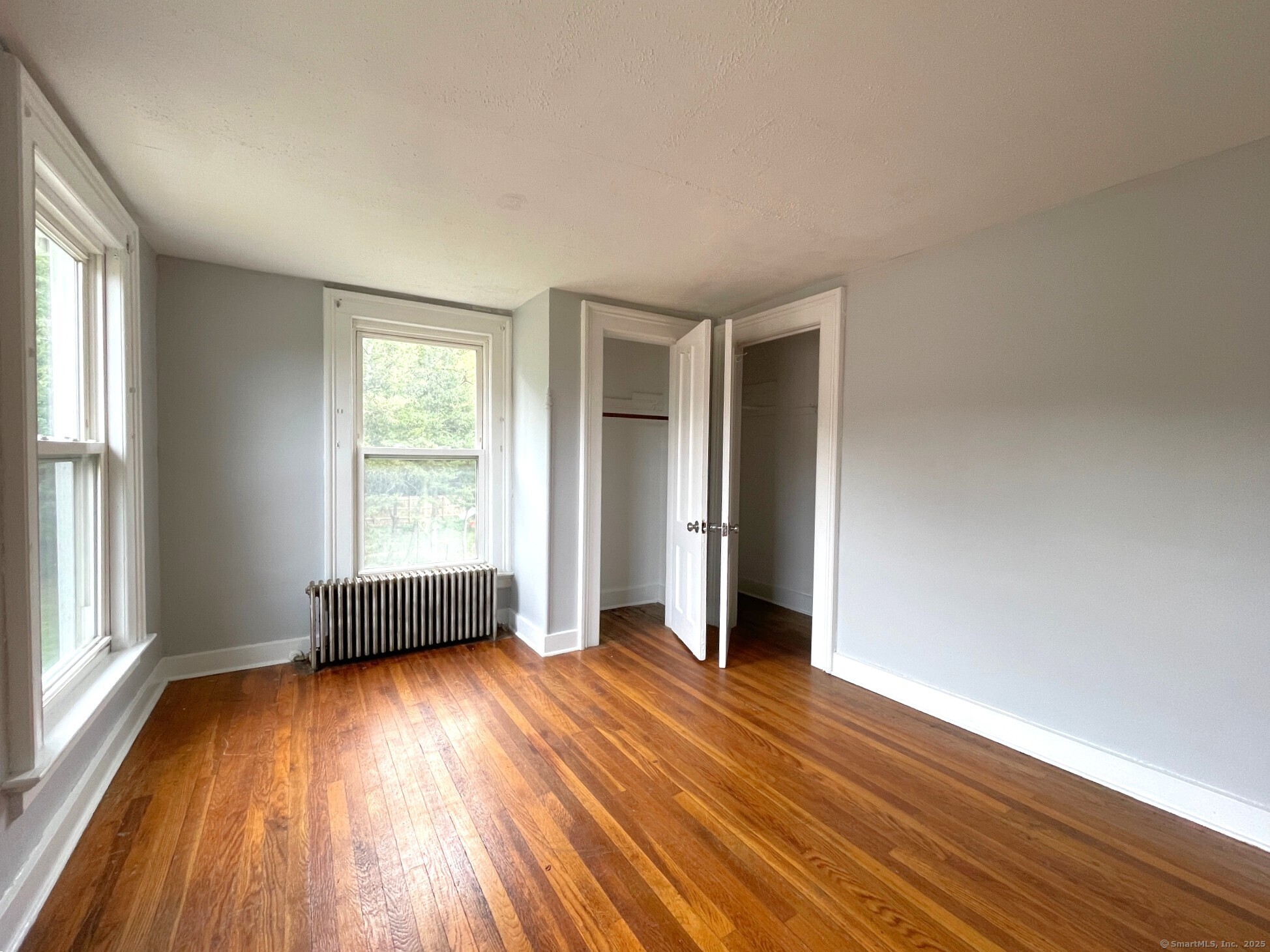 303 Lexington Avenue, Unit 2 New Haven, CT 06513 - Photo 9 of 11 an empty room with wooden floor and windows