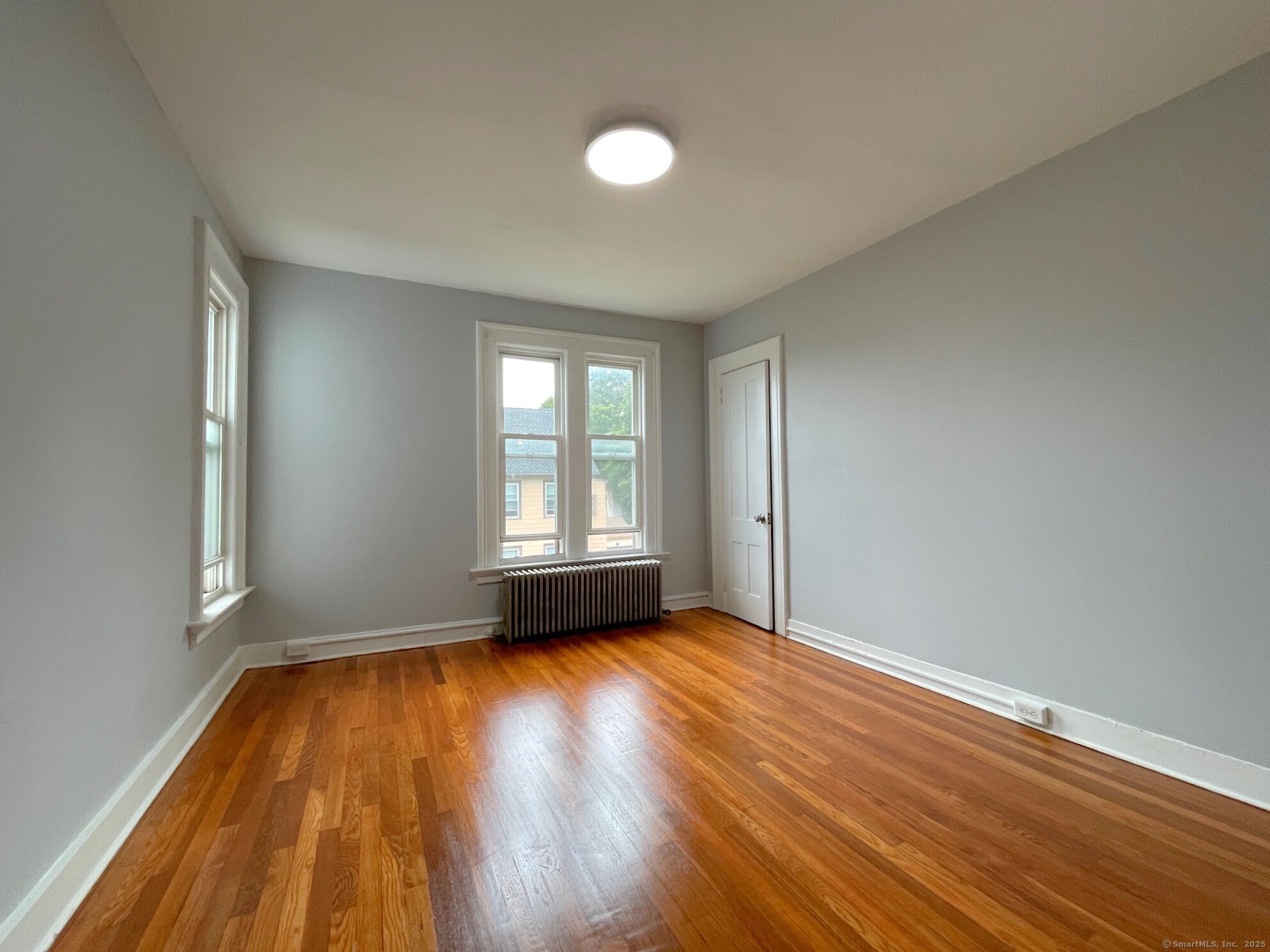 303 Lexington Avenue, Unit 2 New Haven, CT 06513 - Photo 10 of 11 an empty room with wooden floor and windows