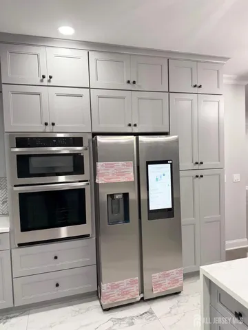 a kitchen with granite countertop white cabinets and stainless steel appliances
