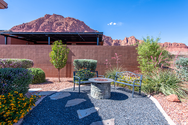 322 340 E Street Ivins, UT 84738 - Photo 54 of 61 Landscaped outdoor area featuring a stone fire pit, decorative benches, and a privacy wall