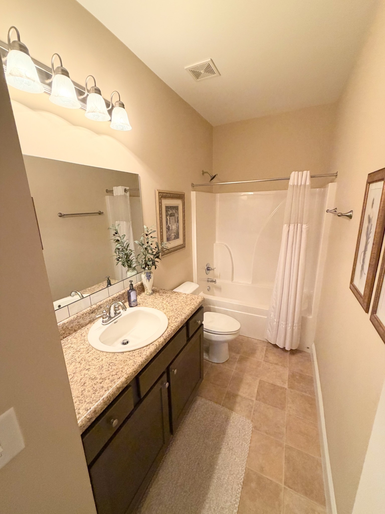 1001 Meadow View Drive Spring Hill, TN 37174 - Photo 28 of 34 a bathroom with a granite countertop sink a toilet a mirror and bathtub