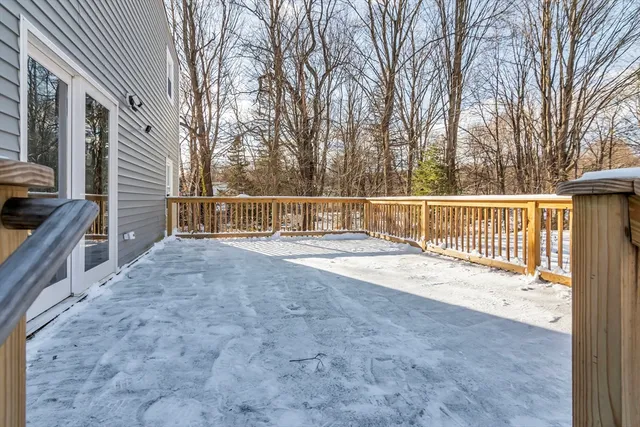 a view of house with backyard and trees in the background