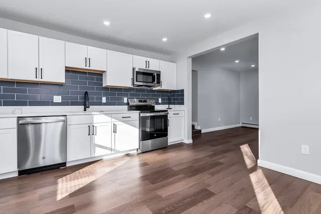 a kitchen with white cabinets stainless steel appliances and sink