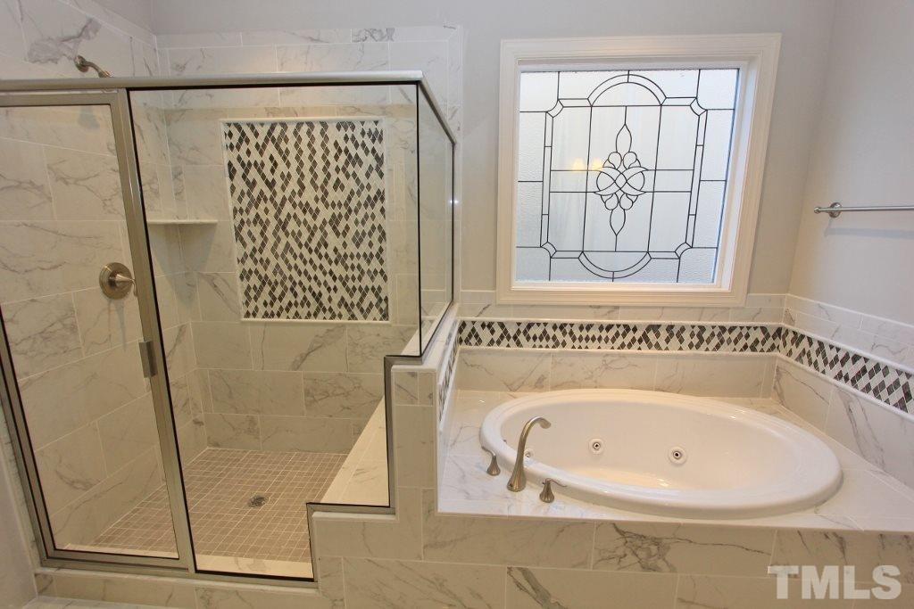 5811 Faringdon Place Raleigh, NC 27609 - Photo 14 of 25 a bathroom with a bathtub and a shower