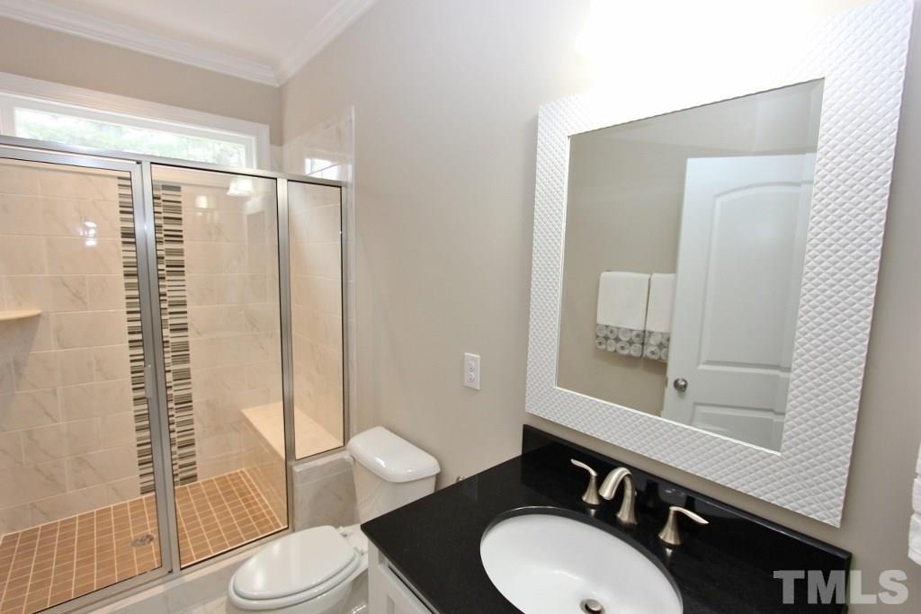 5811 Faringdon Place Raleigh, NC 27609 - Photo 22 of 25 a bathroom with a sink vanity mirror and toilet