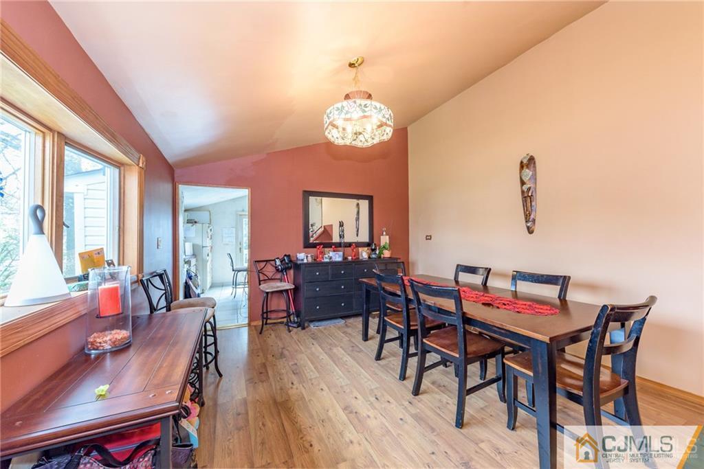 1 Westminster Road Colonia, NJ 07067 - Photo 3 of 25 a dining room with wooden floor a chandelier a wooden table and chairs
