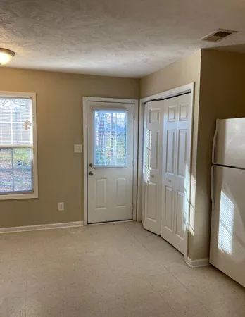 an empty room with windows and closet