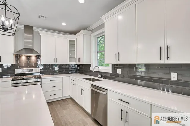a kitchen with granite countertop a sink stainless steel appliances and cabinets