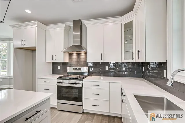 a kitchen with granite countertop a stove sink and cabinets