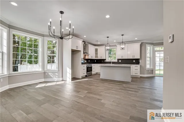 a view of a kitchen with granite countertop stainless steel appliances cabinets a sink and a large window