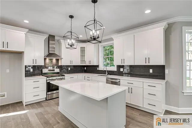 a kitchen with a stove a sink a center island and cabinets