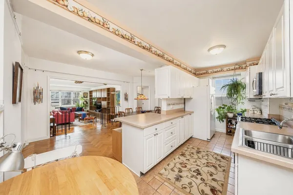 a room with stainless steel appliances kitchen island granite countertop lots of counter top space