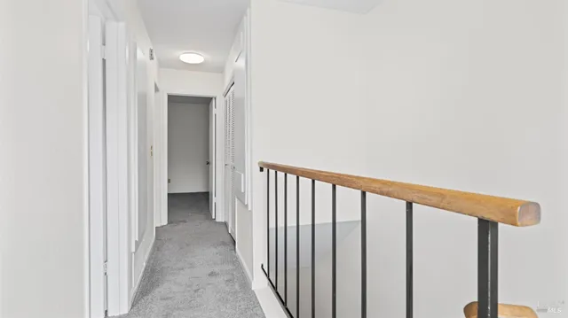 a view of a hallway with wooden floor and entryway