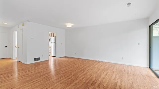 a view of an empty room with wooden floor