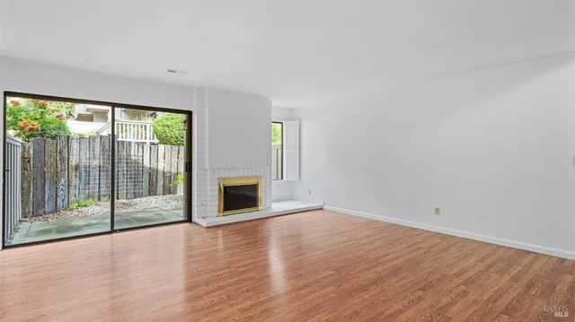 wooden floor fireplace and natural light in room